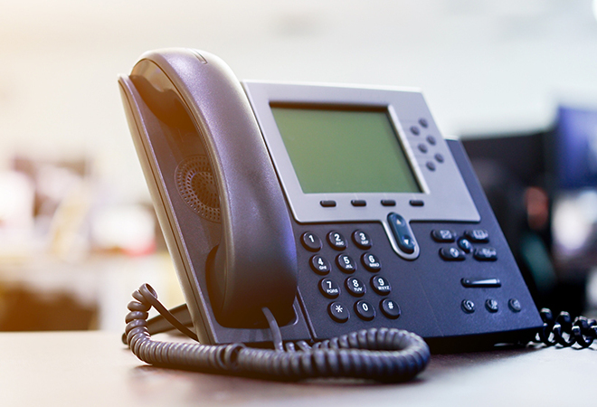 close up soft focus on telephone devices at office desk for customer service support concept